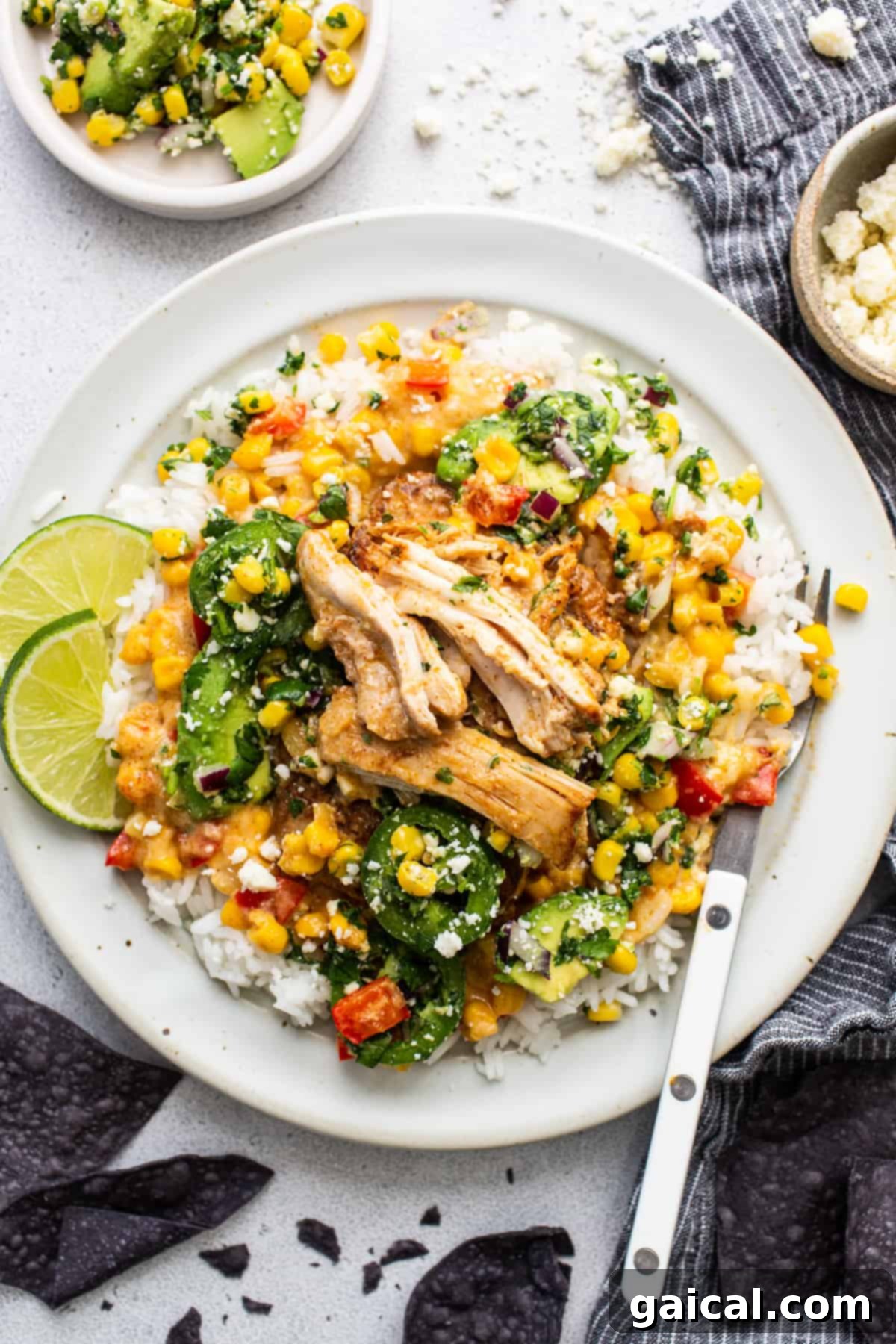 A close-up of a white plate with creamy street corn chicken, showcasing the texture and garnish.