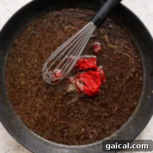 A frying pan with a red pepper in it.