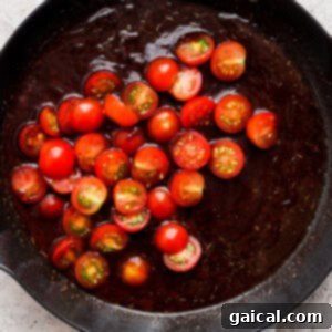 A frying pan with tomatoes in it.