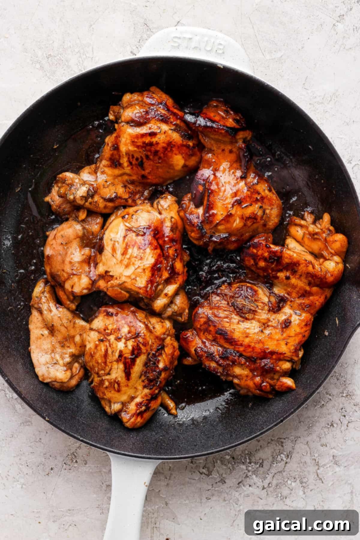 Rich Balsamic Glazed Chicken Thighs 3 Grilled chicken in a skillet on a white background.