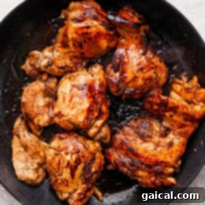 Rich Balsamic Glazed Chicken Thighs 6 Grilled chicken in a skillet on a white background.