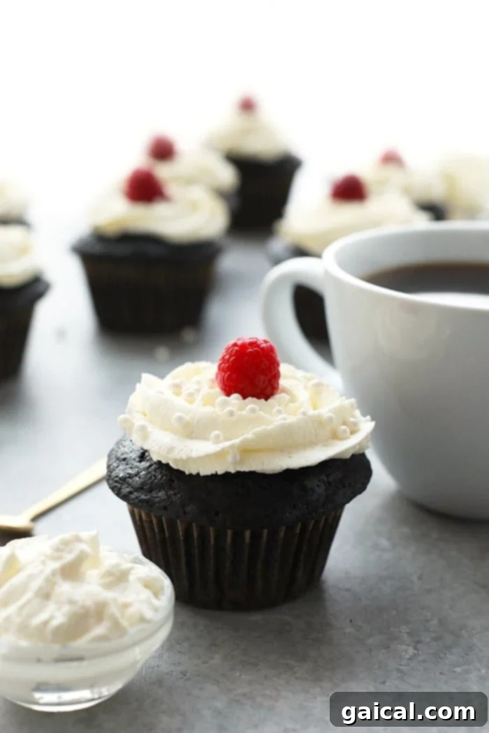 Delicious healthier chocolate cupcakes topped with a fresh raspberry, perfect for a guilt-free dessert