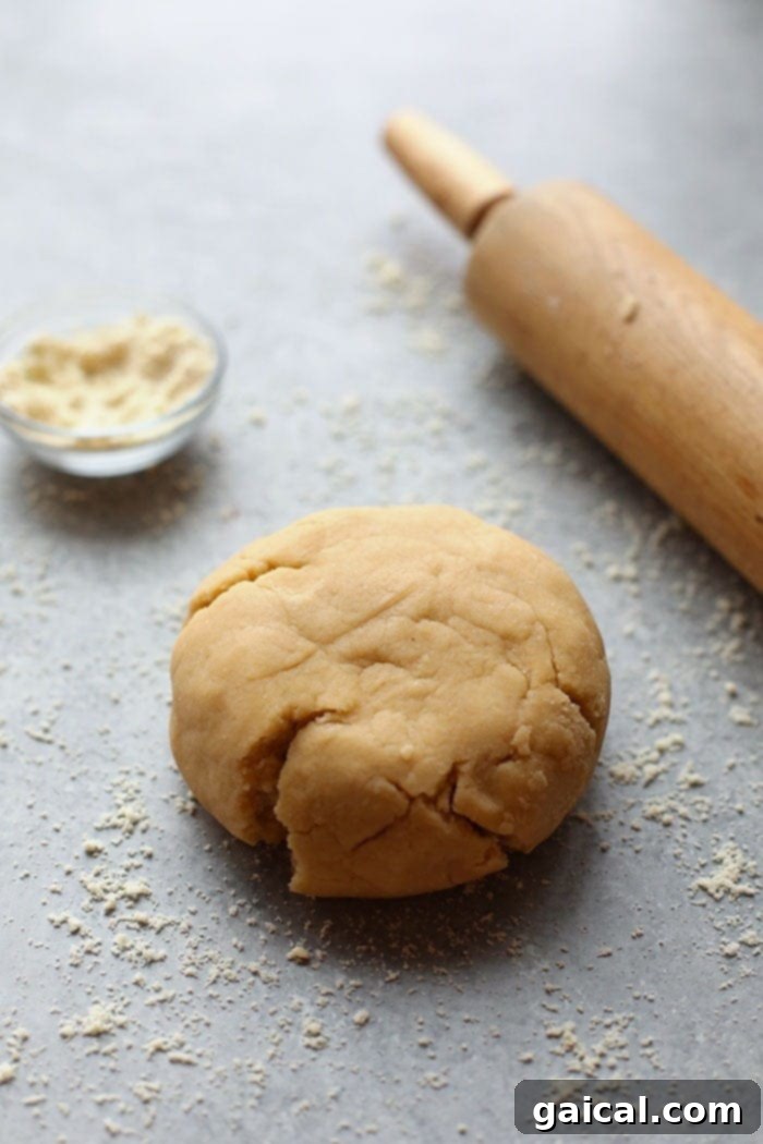 These healthy gluten free cookies are made with almond meal and honey for a grain-free, paleo-friendly sugar cookie! Make a batch today! Rolling out healthy sugar cookie dough