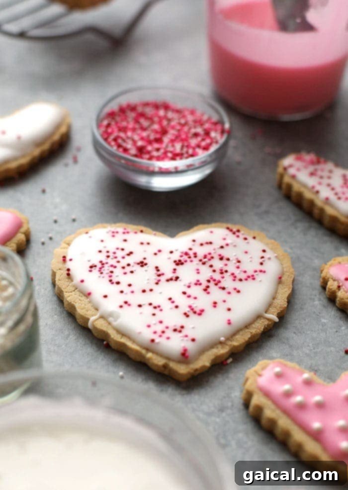Our healthy sugar cookies are made with the base of almond flour and coconut flour and are sweetened with honey. That's right, no white sugar involved! Healthy sugar cookies with pink frosting on a counter