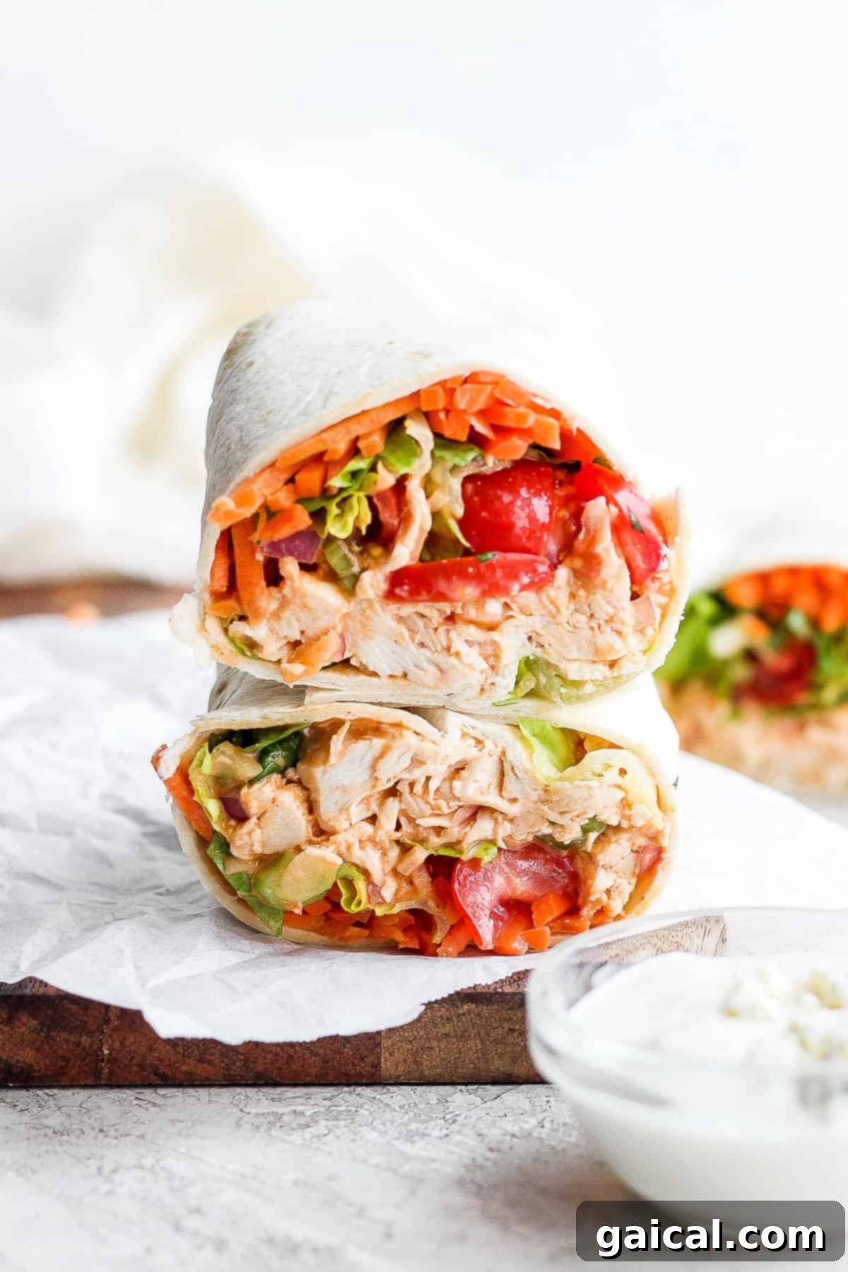 Delicious Protein-Packed Buffalo Chicken Wraps Stacked protein-packed buffalo chicken wraps with fresh vegetables, featuring creamy blue cheese and our signature buffalo sauce, ready for a healthy and satisfying meal.