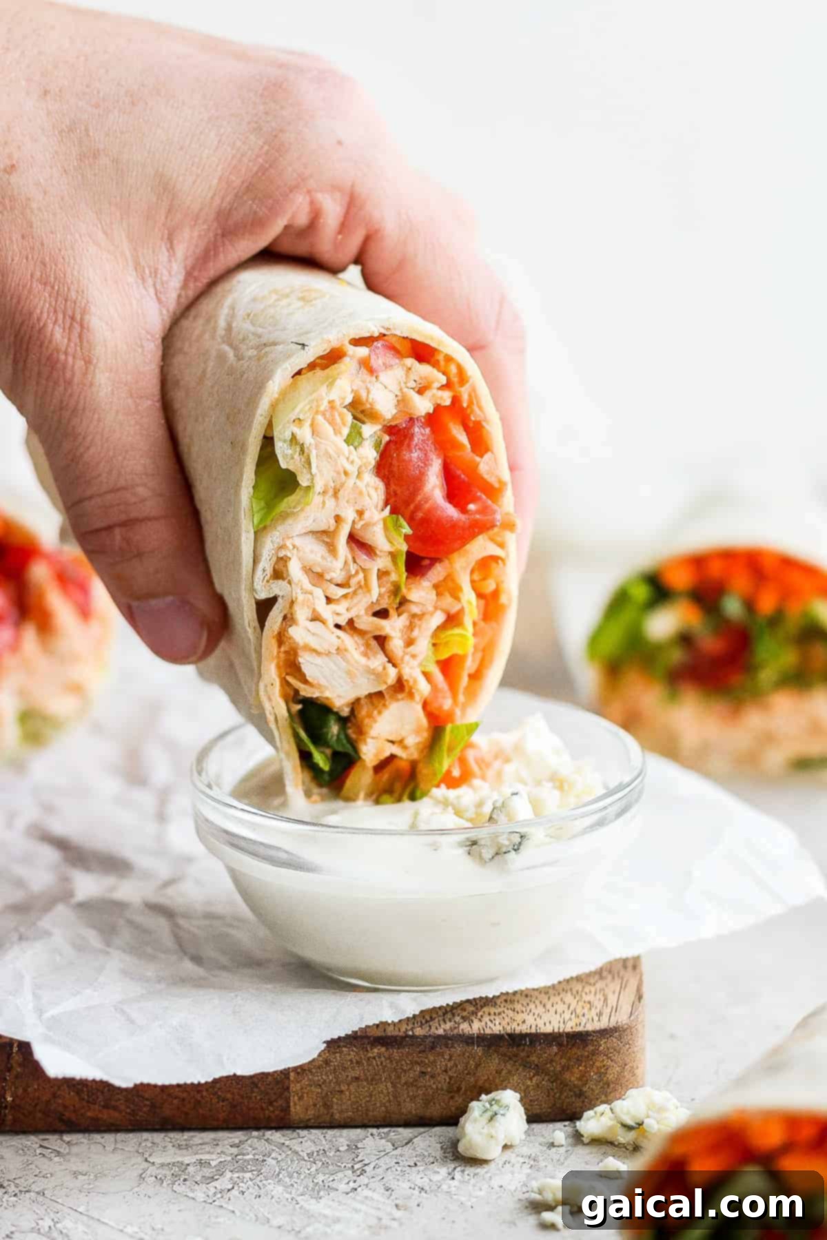 Buffalo Chicken Wrap Detail Close-up of a buffalo chicken wrap, with a cross-section showing the rich filling of shredded chicken, vegetables, and blue cheese, ready for a delicious bite.
