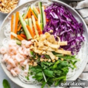 Fresh Spring Roll Bowl 9 A large bowl of vibrant Vietnamese noodle salad, featuring shrimp, fresh vegetables, and an assortment of aromatic herbs, awaiting its flavorful dressing.