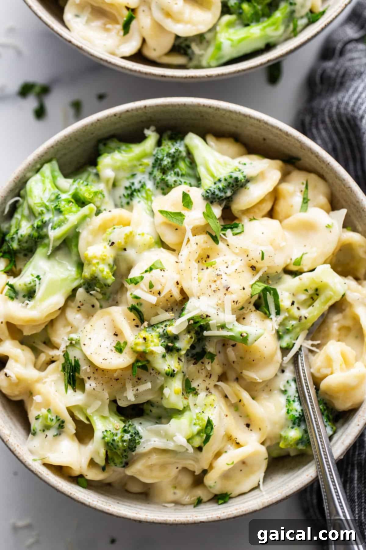 Velvety Broccoli Pasta 2 Two bowls of pasta with broccoli and parmesan cheese, ready to be served.