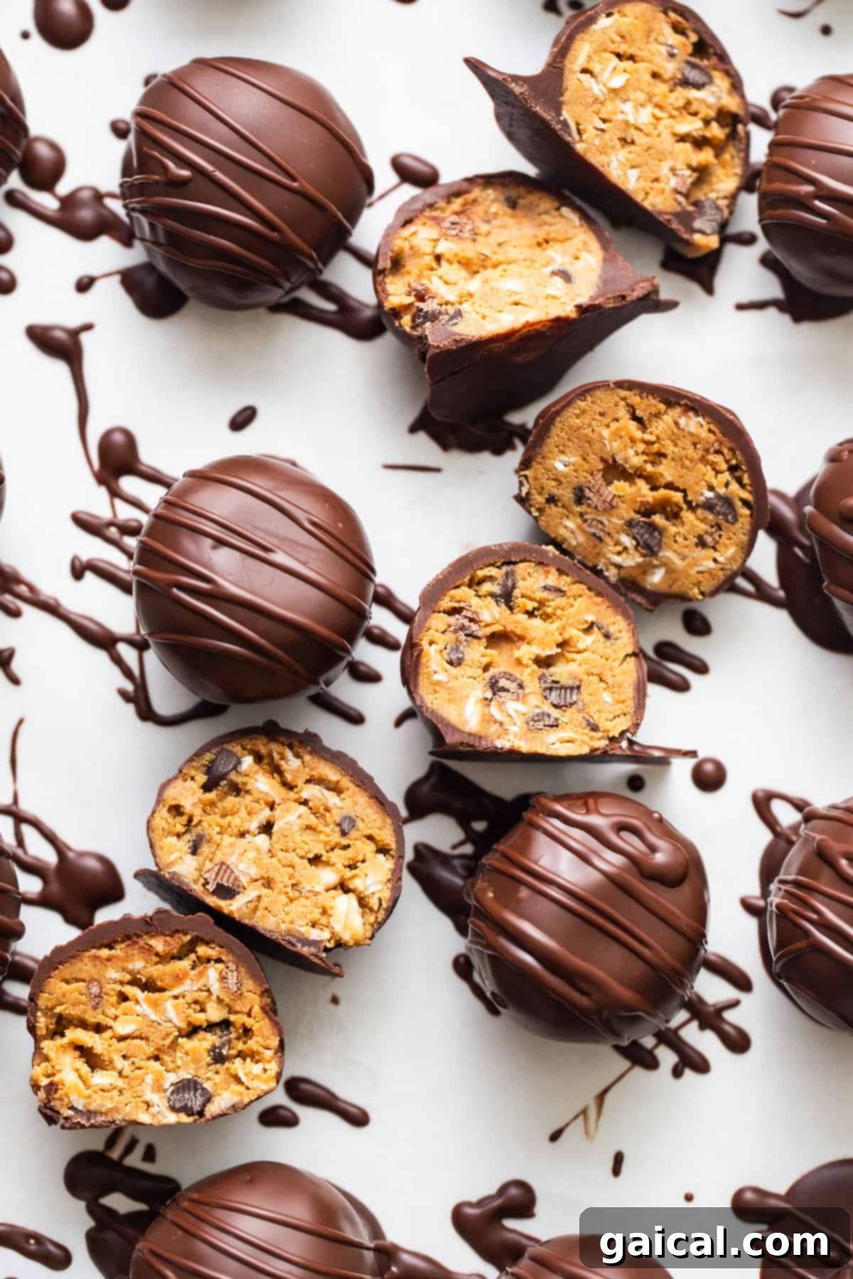 Chocolate covered peanut butter balls on a white surface.