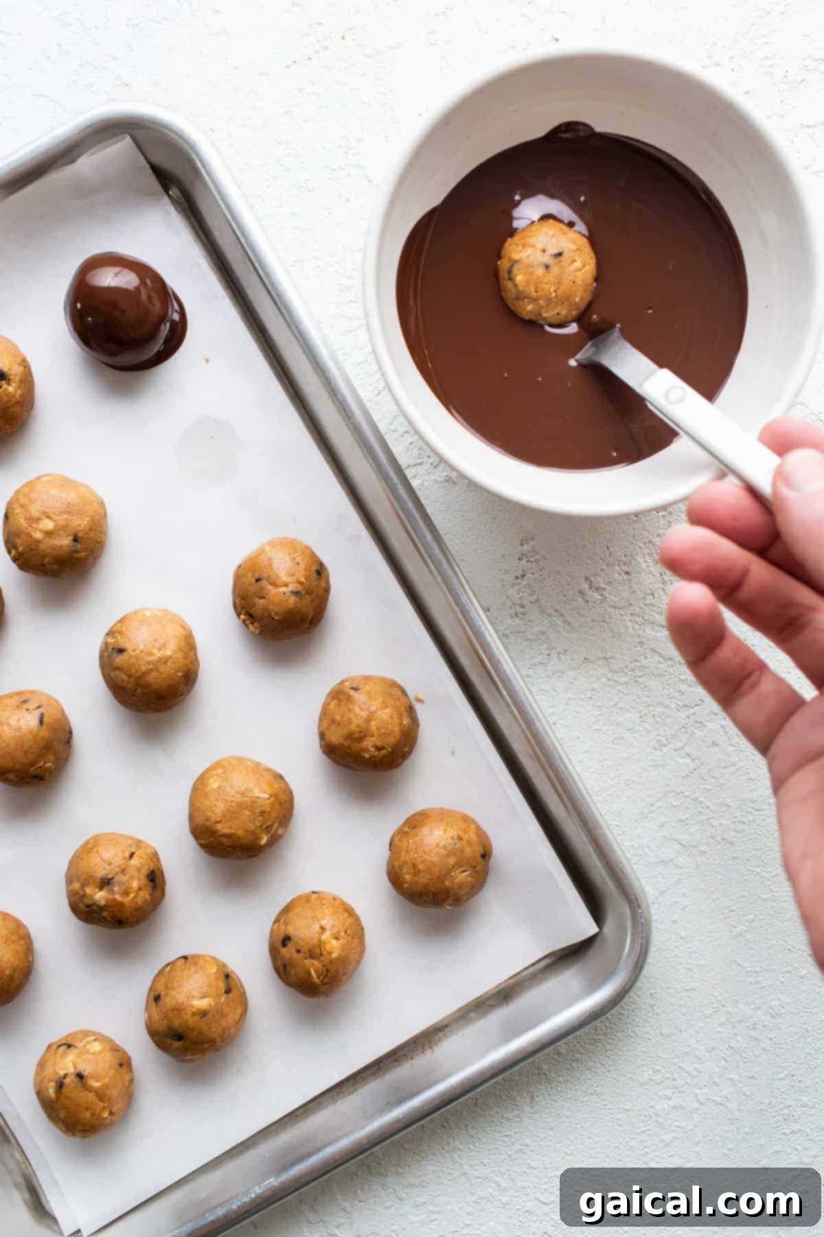 A person is pouring chocolate on a baking sheet.