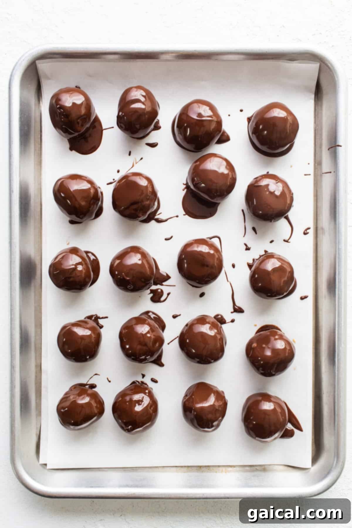Chocolate covered peanuts on a baking sheet.