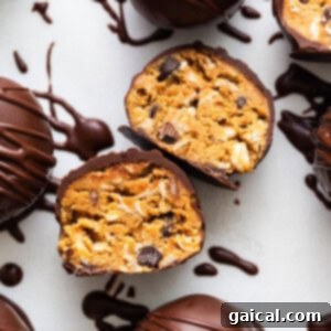 Chocolate covered peanut butter truffles on a white surface.