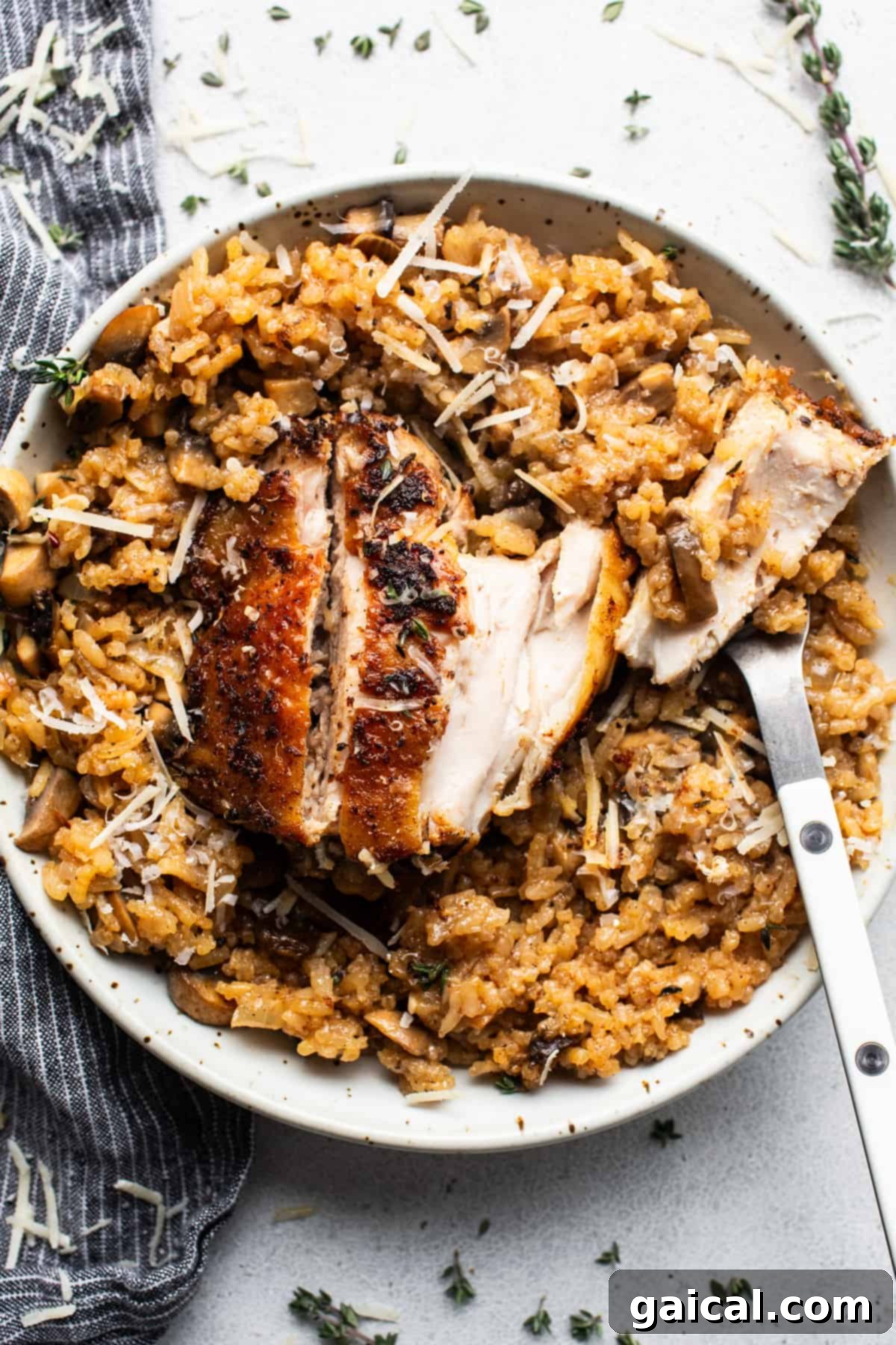 Chicken risotto with mushrooms and thyme on a plate.