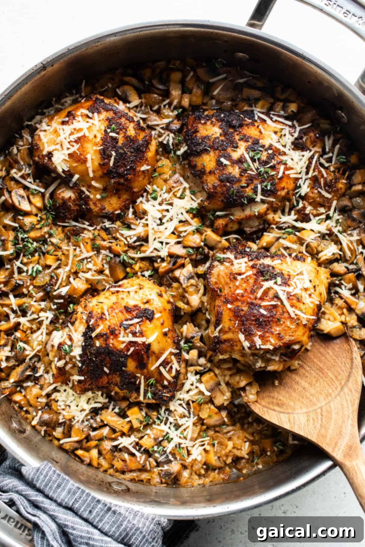A pan with chicken and mushrooms in it.