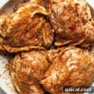 Seasoned chicken breasts in a white plate.