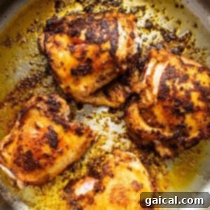 Roasted chicken in a skillet on a white background.