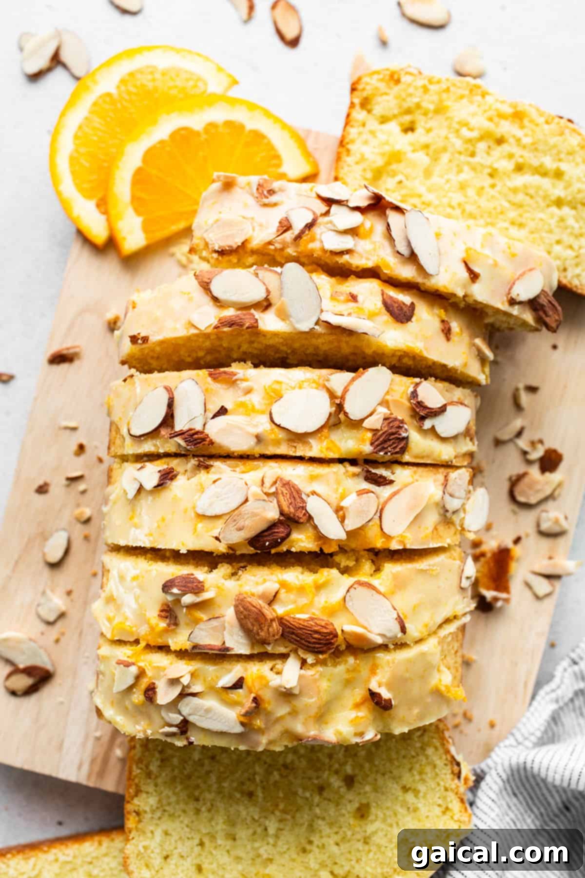 Sun-Kissed Orange Cake 2 A slice of bread with almonds on a cutting board.