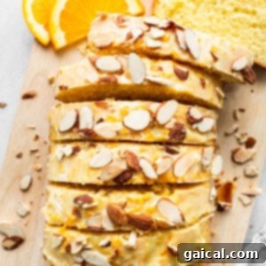 Sun-Kissed Orange Cake 12 A slice of bread with almonds on a cutting board.