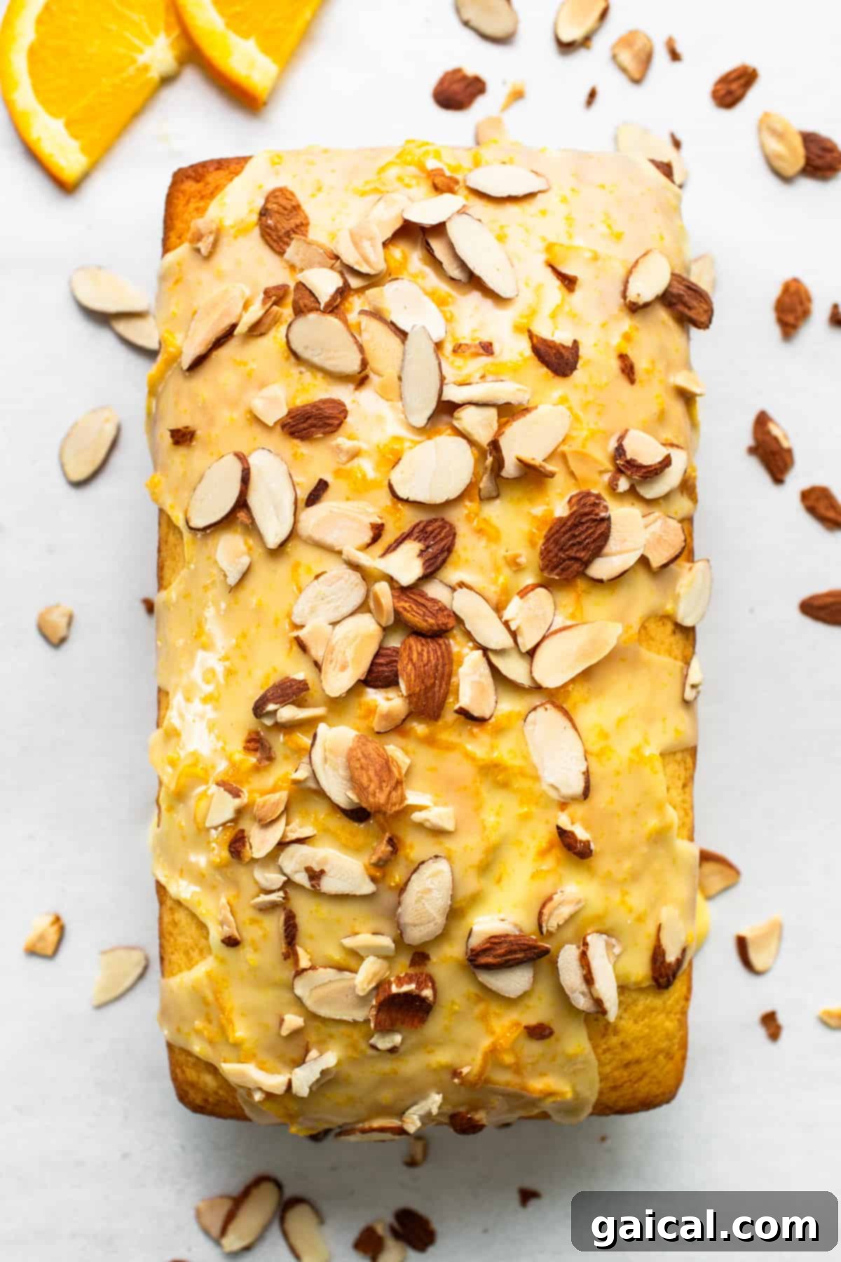 Sun-Kissed Orange Cake 4 A loaf of orange bread with almonds and orange slices.