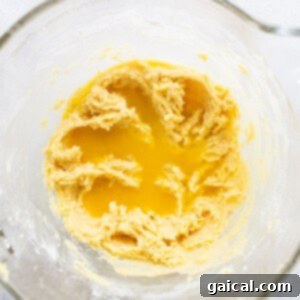 Sun-Kissed Orange Cake 9 A glass bowl with a yellow batter in it.