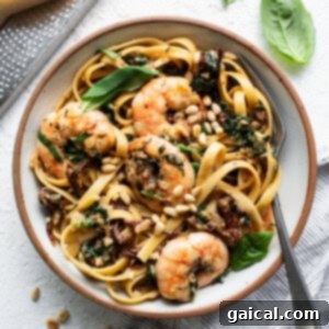 Creamy Tuscan Shrimp Linguini 11 A bowl of creamy pasta with shrimp and basil, ready to eat.