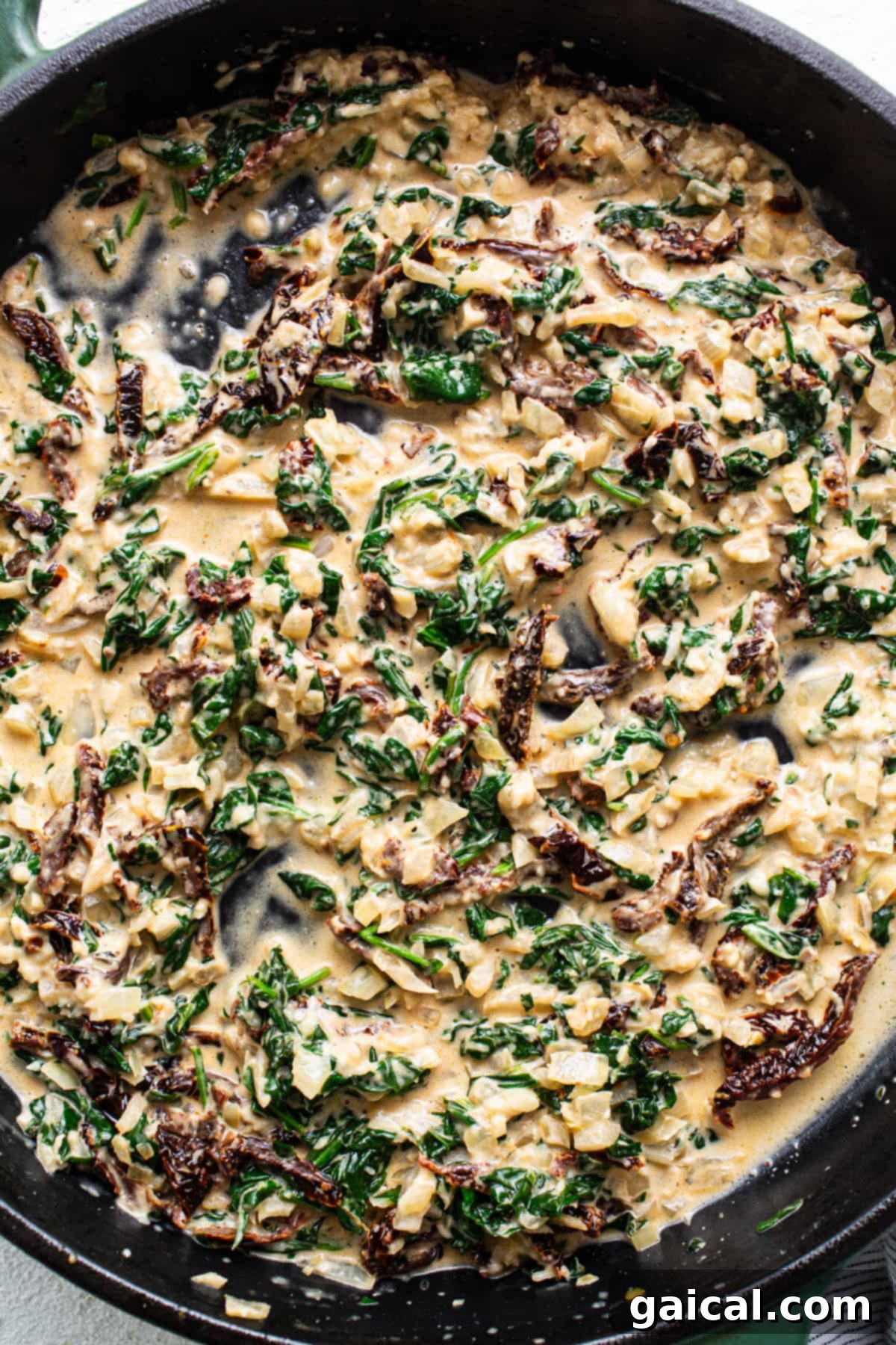 Creamy Tuscan Shrimp Linguini 13 A skillet filled with sautéed spinach and mushrooms.