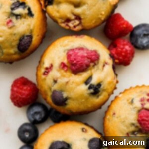 A charming close-up of a group of Greek yogurt berry muffins, showcasing the delicate crumble and the fresh berries on top, ready to be enjoyed.