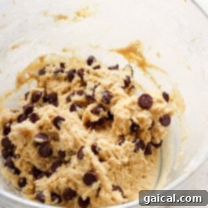 A bowl filled with freshly prepared chocolate chip cookie dough, demonstrating its readiness for baking.