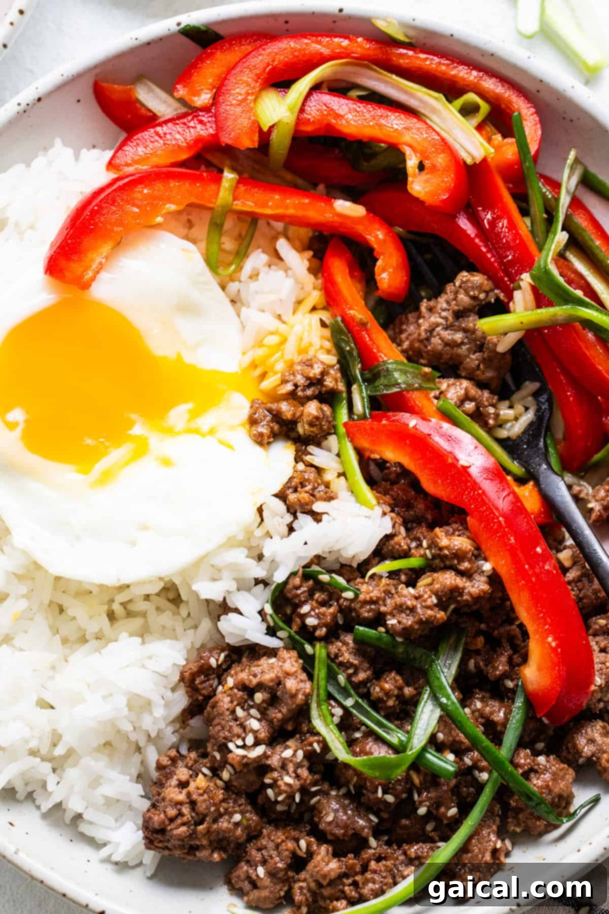 Sweet and Spicy Korean Ground Beef 5 Bibimbap with Korean ground beef, vegetables, and a sunny-side-up egg in a bowl.