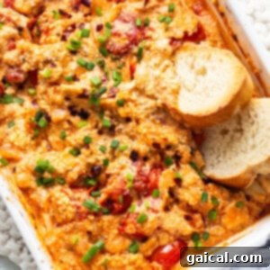 A casserole dish with chicken, tomatoes and bread.