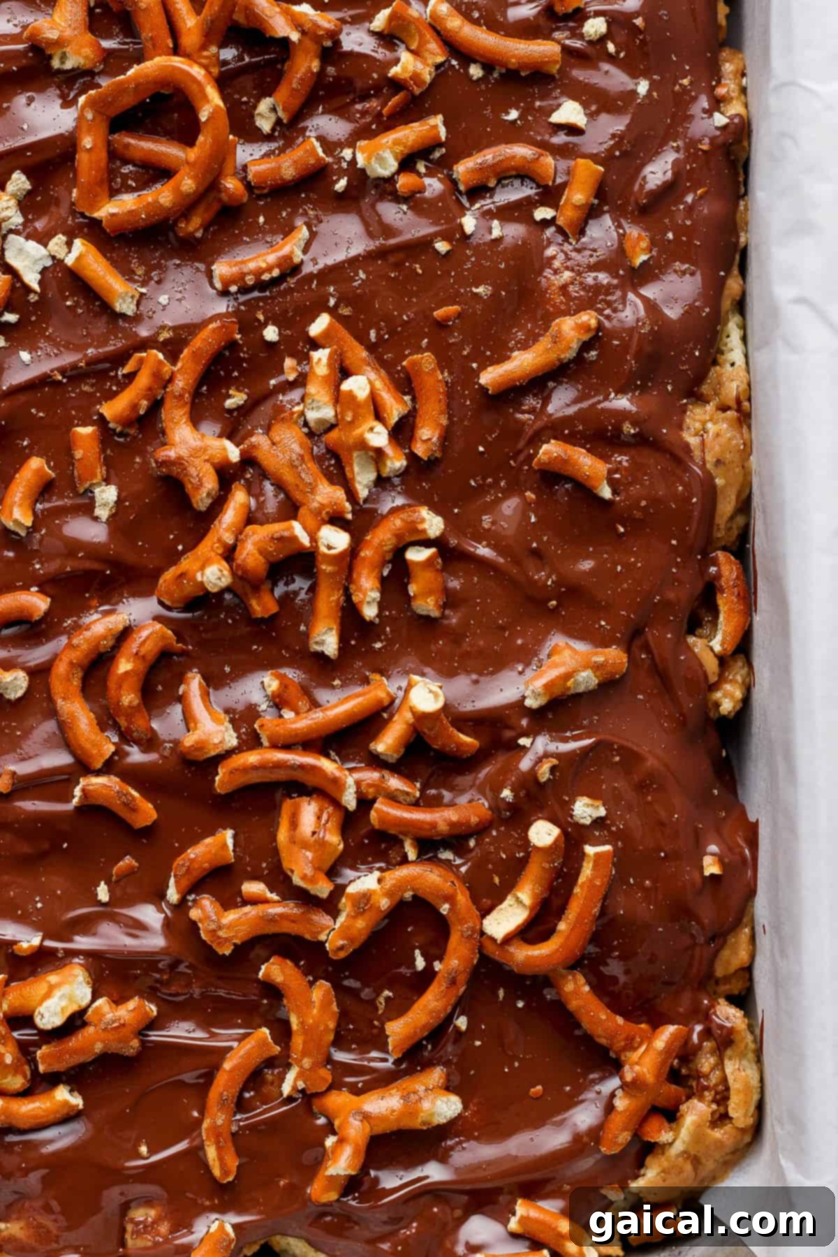 A tray of chocolate-covered toffee topped with pretzels.