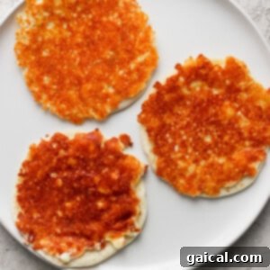 Three golden-brown cheese pancakes on a white plate with a light textured background.