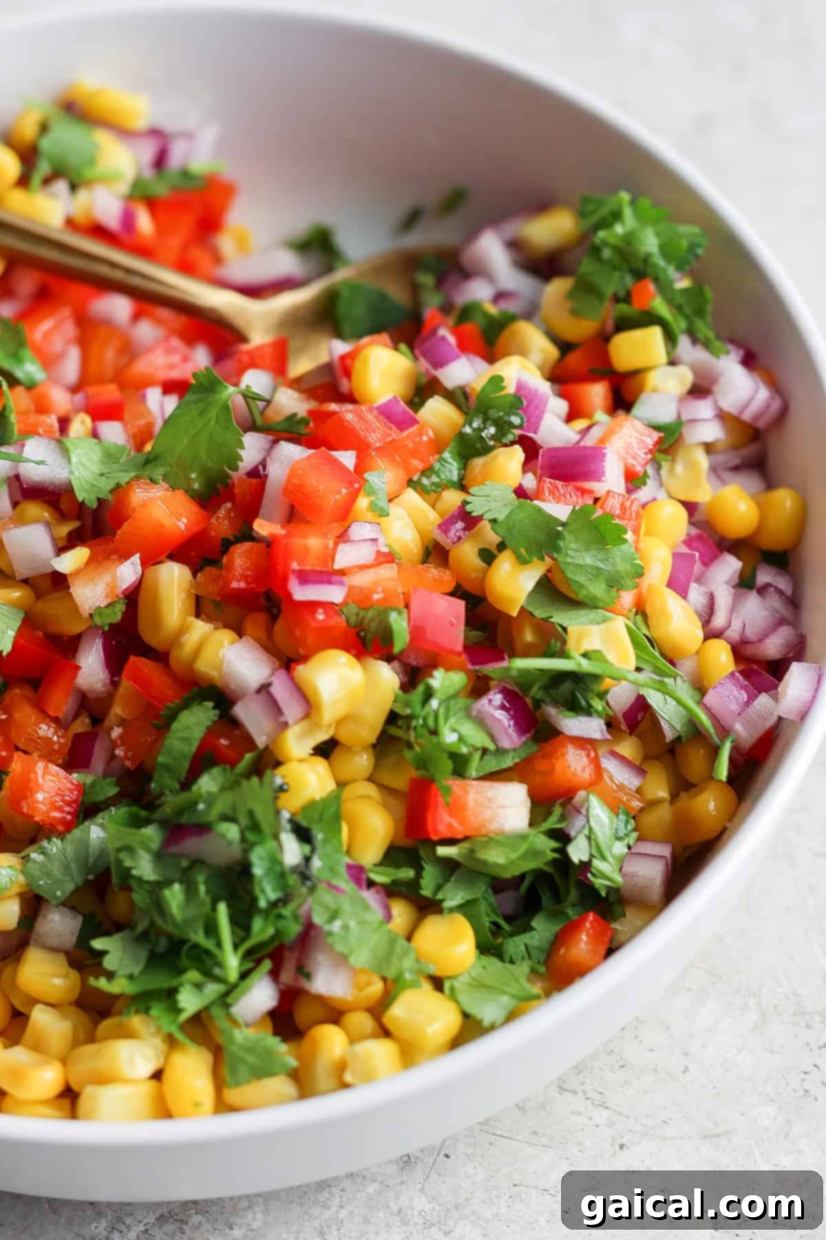 Zesty Cotija Chicken Tacos 4 A vibrant bowl of corn salsa with diced red onions, chopped tomatoes, and fresh cilantro.