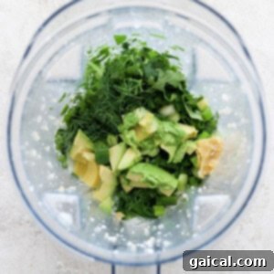 Vibrant Green Goddess Quinoa Bowl 10 Ingredients including herbs, avocado, and banana prepared in a blender ready for blending.