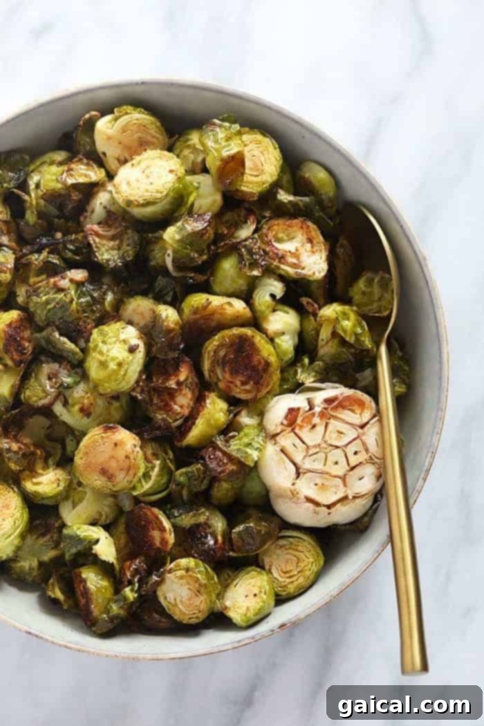 Discover how to make simple roasted Brussels sprouts with olive oil and spices for a crispy, caramelized finish every time! A bowl of perfectly roasted Brussels sprouts, golden-brown and crispy, ready to be served.