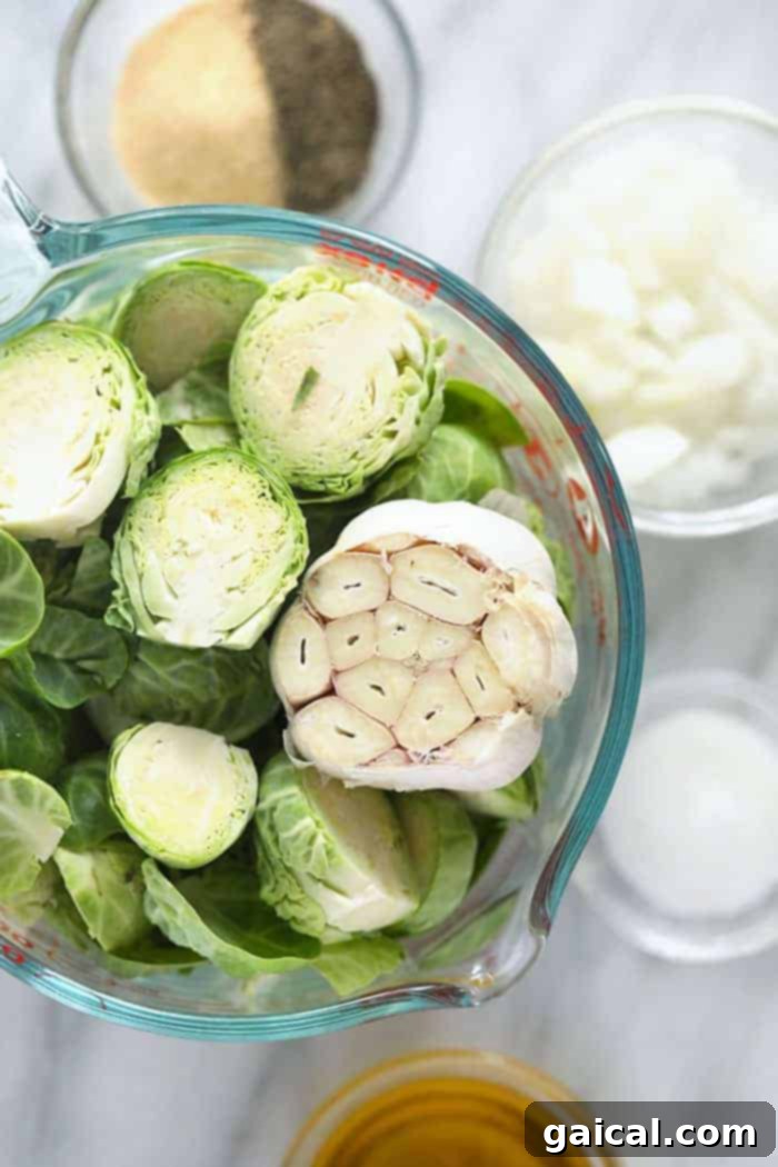 This easy roasted Brussels sprouts recipe, featuring olive oil and spices, promises crispy, caramelized results every time! Fresh Brussels sprouts and a whole head of garlic ready for roasting on a cutting board, pre-prepped.