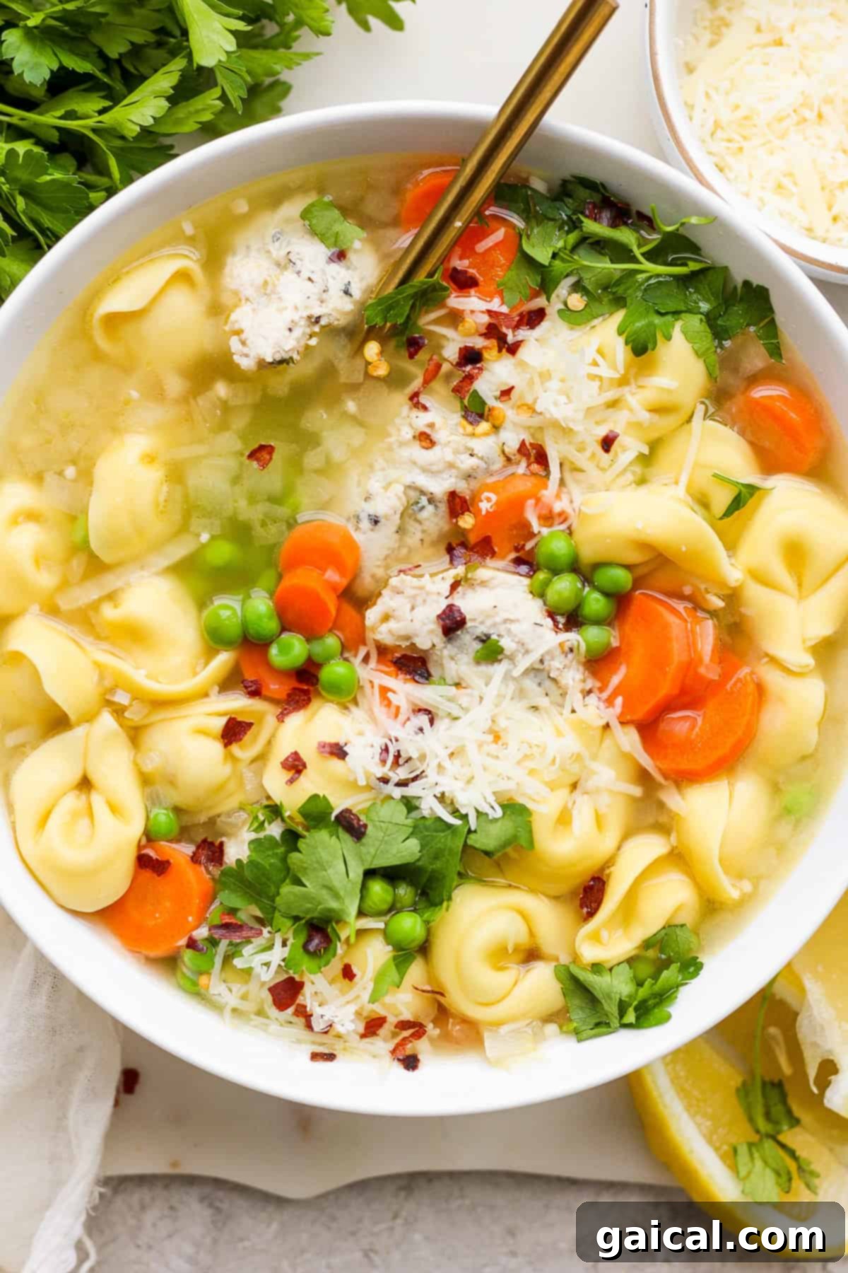 A cozy bowl of chicken noodle soup with vibrant vegetables, generously topped with freshly grated parmesan cheese and fresh herbs, ready to be enjoyed.