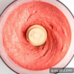 Strawberry Soft Swirl 9 Top view of a food processor containing freshly blended strawberry puree.