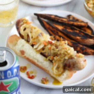 A close-up of sizzling beer-boiled bratwursts on a grill, perfectly charred with savory seasonings, ready to be served or added to a protein bowl.