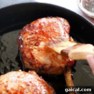 Baked pork chops on cast iron skillet, golden brown and ready to serve