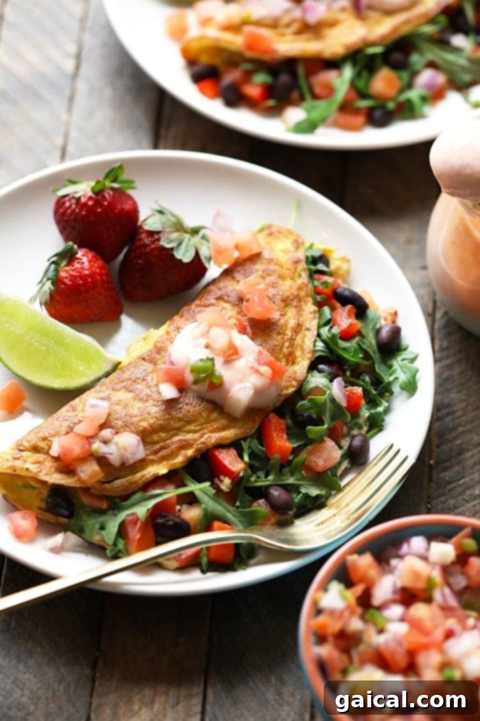 Garden Fresh Omelet 2 A vibrant, protein-packed veggie omelette, beautifully plated with a side of black beans and fresh strawberries, perfect for a balanced and healthy breakfast.