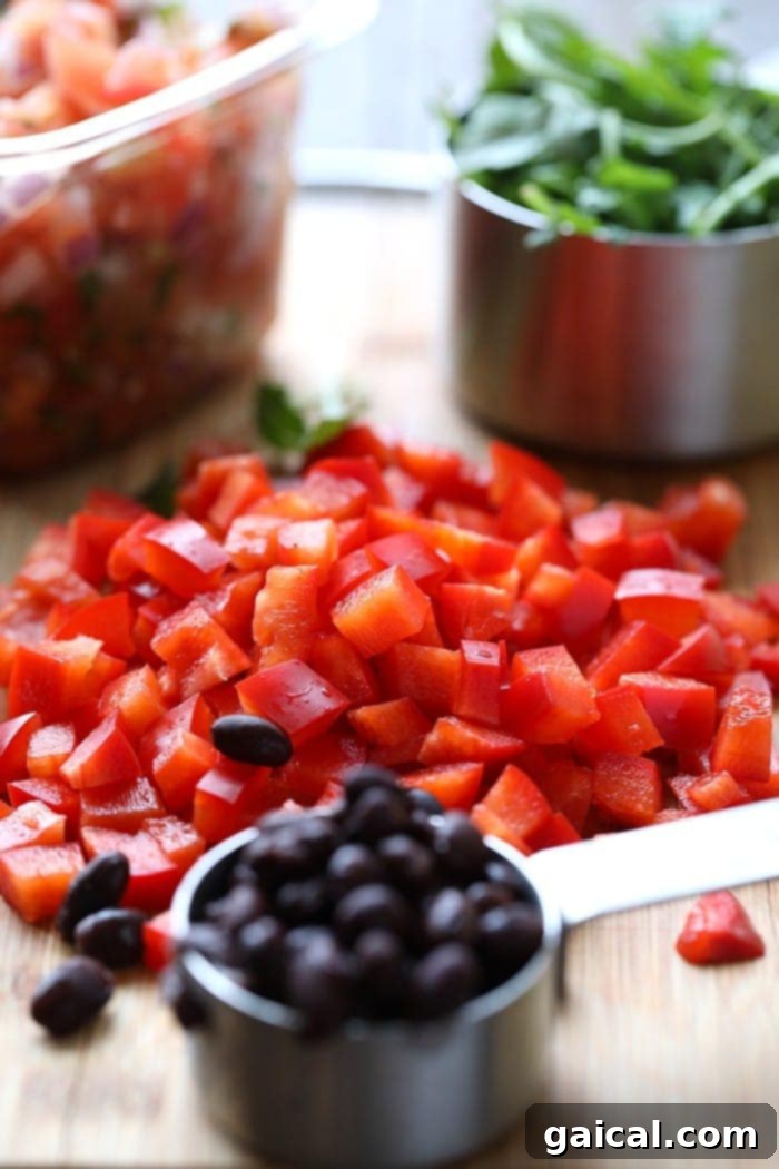 Garden Fresh Omelet 3 Close-up photo displaying freshly diced red bell peppers and a measuring cup brimming with black beans, showcasing vibrant ingredients ready for a healthy veggie omelette.