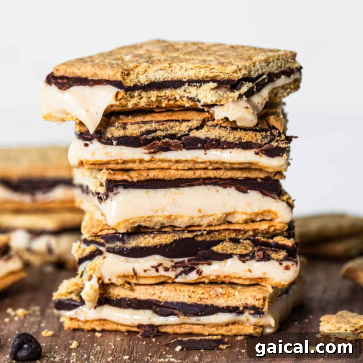 Peanut Butter Protein Smores Freeze 2 A stack of s'mores with a creamy filling and melted chocolate between graham crackers, set against a rustic wooden backdrop.