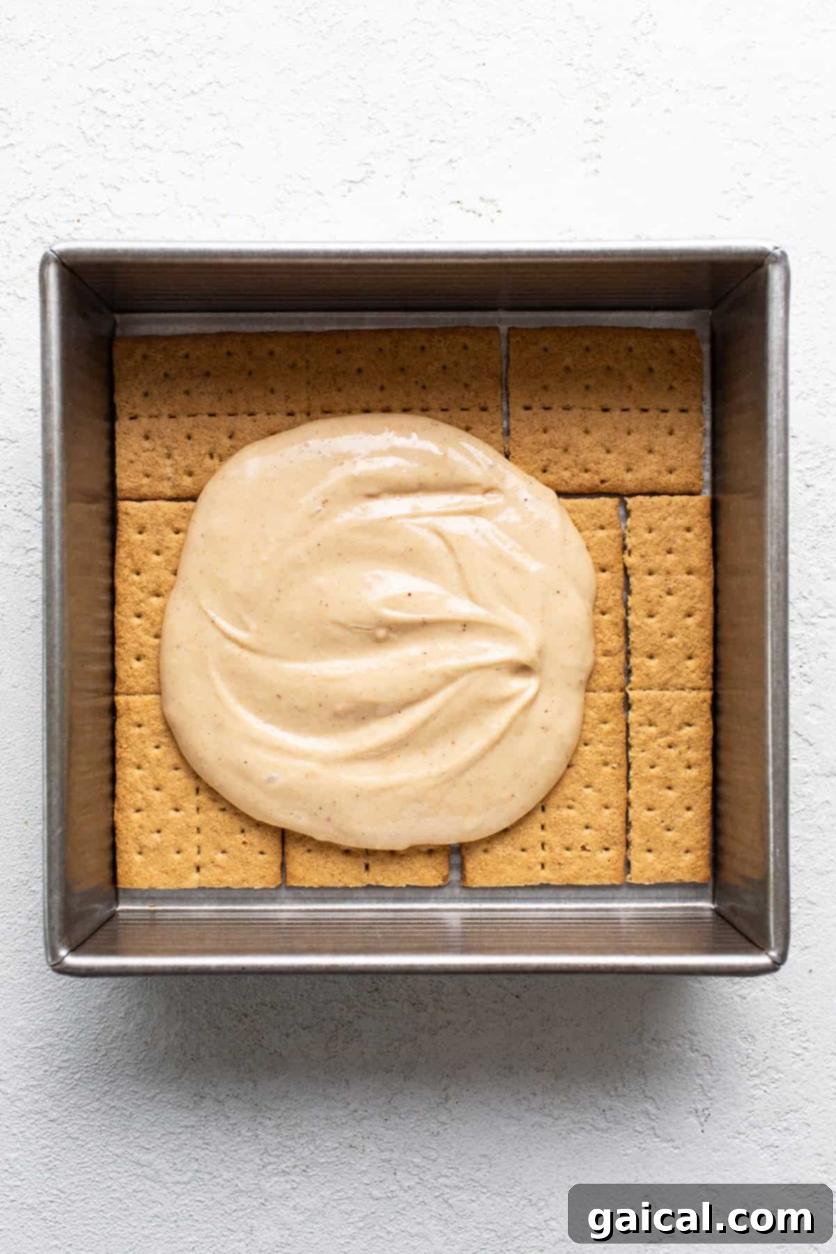 Peanut Butter Protein Smores Freeze 4 A square baking dish filled with graham crackers topped with a thick, smooth, creamy protein-rich filling.