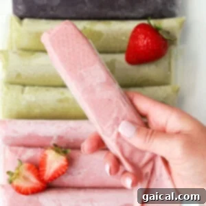 Zesty Coconut Key Lime Frozen Treats 4 En person som holder en jordbæris foran en haug med jordbær.