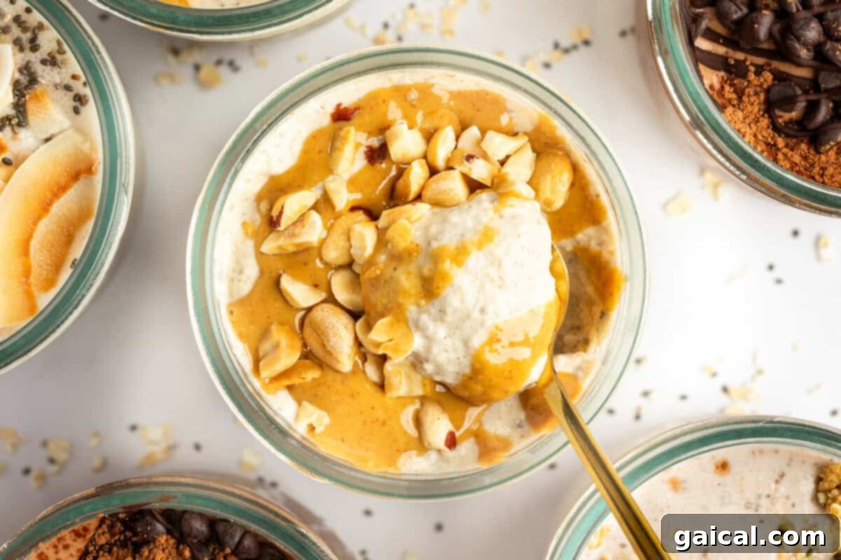 A bowl of creamy oatmeal topped with peanut butter and chopped nuts. A gold spoon is partially submerged in the oatmeal. Other bowls of similarly prepared oatmeal surround it.