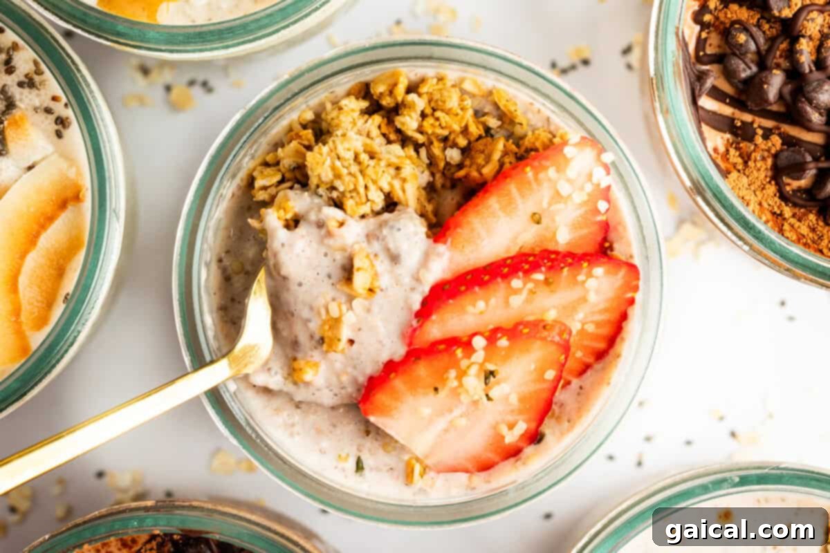 A bowl of oatmeal topped with sliced strawberries, granola, and a gold spoon placed in it.
