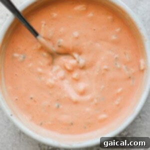 Confetti Corn Smash Burger 8 A bowl of creamy tomato soup with herbs, served with a spoon. (Note: Image used as placeholder, visually representing a sauce bowl).