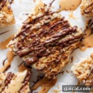 Close-up of toasted rice Krispie treats dessert bars topped with caramel and chocolate drizzle on a parchment paper background.