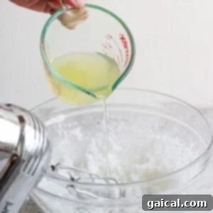 Golden Pineapple Flips 10 Pineapple juice being slowly poured into the wet mixture in a bowl.